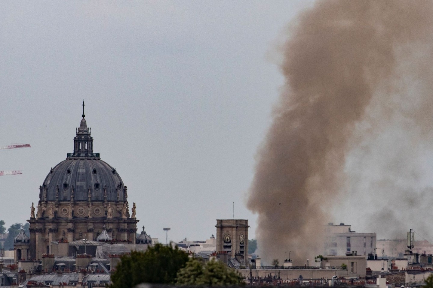 Rauch steigt aus einem Gebäude am Place Alphonse-Laveran in der Nähe des Doms des Val de Grace (l) in Paris auf.