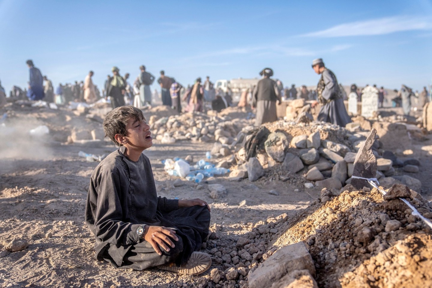 Ein Junge trauert neben dem Grab seines kleinen Bruders, der in der Provinz Herat im Westen Afghanistans ums Leben gekommen ist.