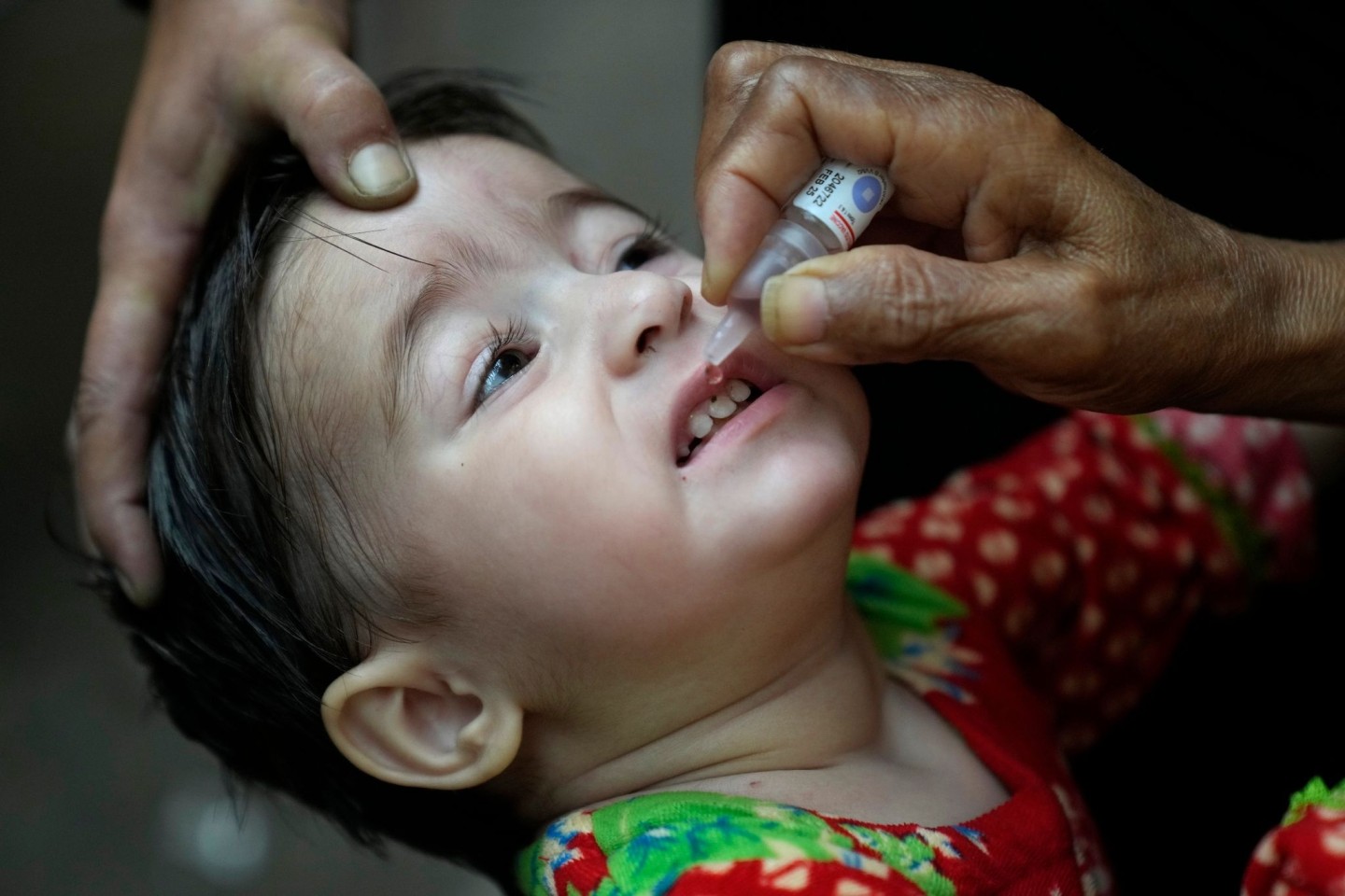 Ein Gesundheitshelfer verabreicht einem Kind einen Polio-Impfstoff.