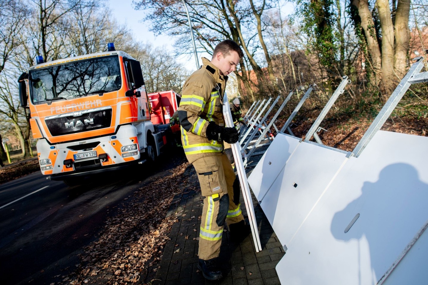 Einsatzkräfte der Feuerwehr bauen ein mobiles Deichsystem ab.