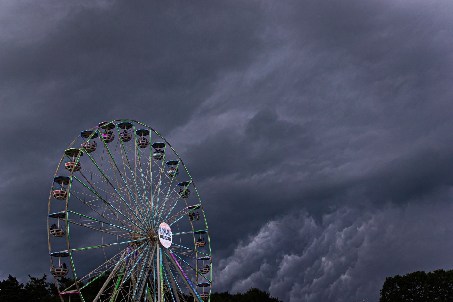 Dunkle Regenwolken ziehen über ein Riesenrad auf dem Gelände des Hurricane-Festivals in Scheeßel hinweg.