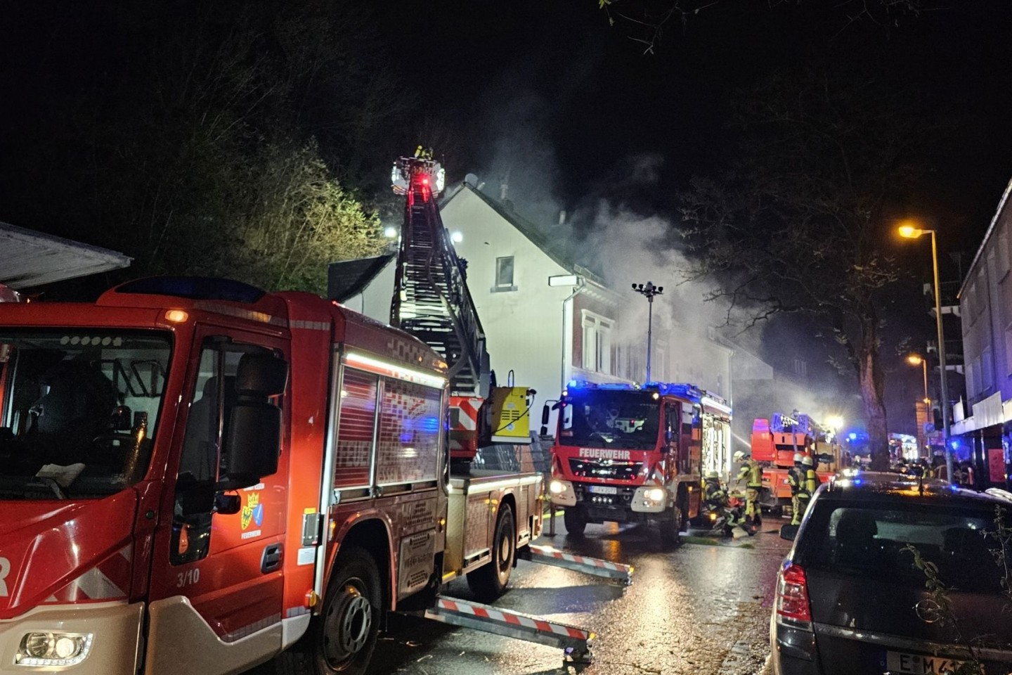 Feuerwehrleute löschen von einer Drehleiter aus.