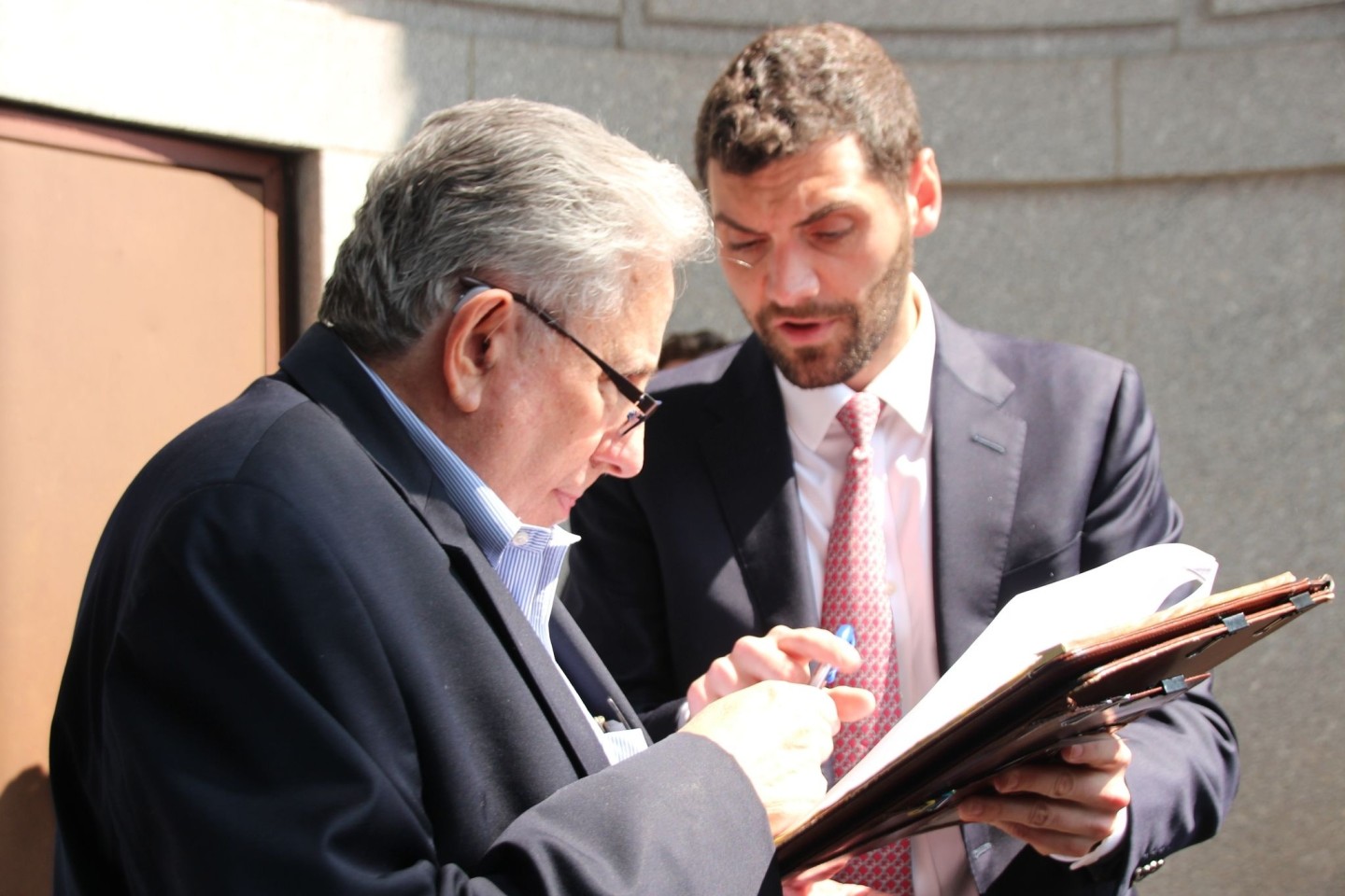 Nach der Auktion bekommt Jeff Gural (l) von Auktionator Matthew Mannion einen Stift gereicht.