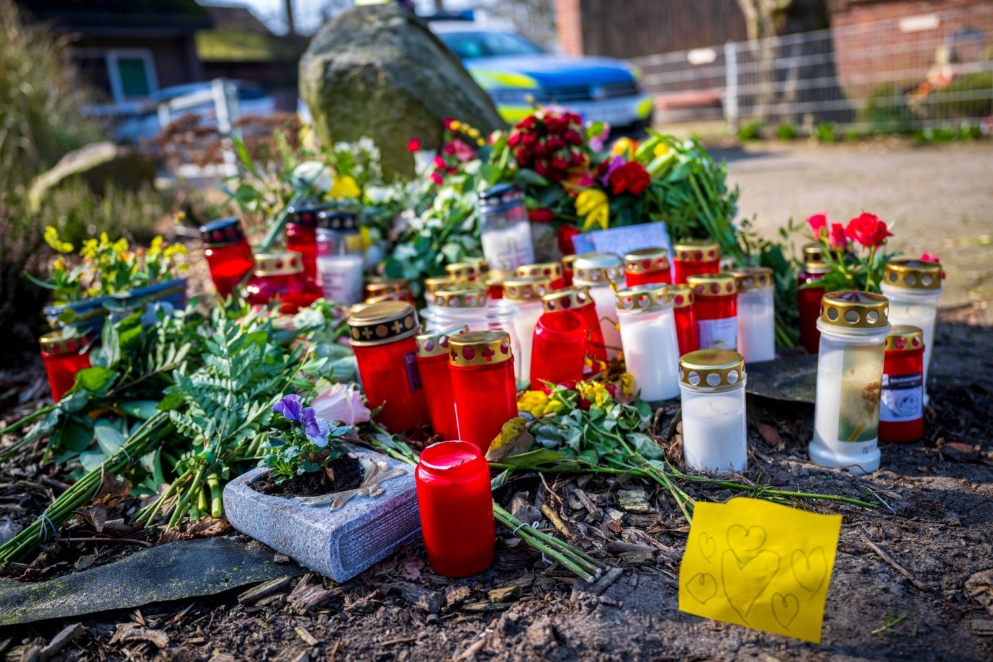 Blumen und Kerzen liegen vor einem Einfamilienhaus in Scheeßel.