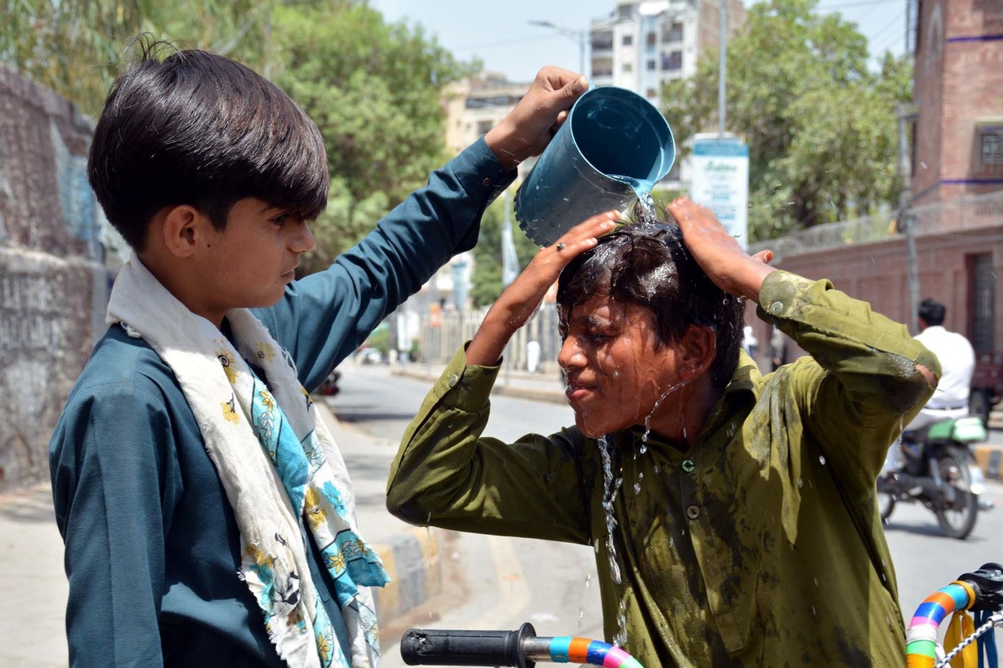 Ein Junge wäscht sich in Pakistan den Kopf, um sich an einem heißen Sommertag abzukühlen.