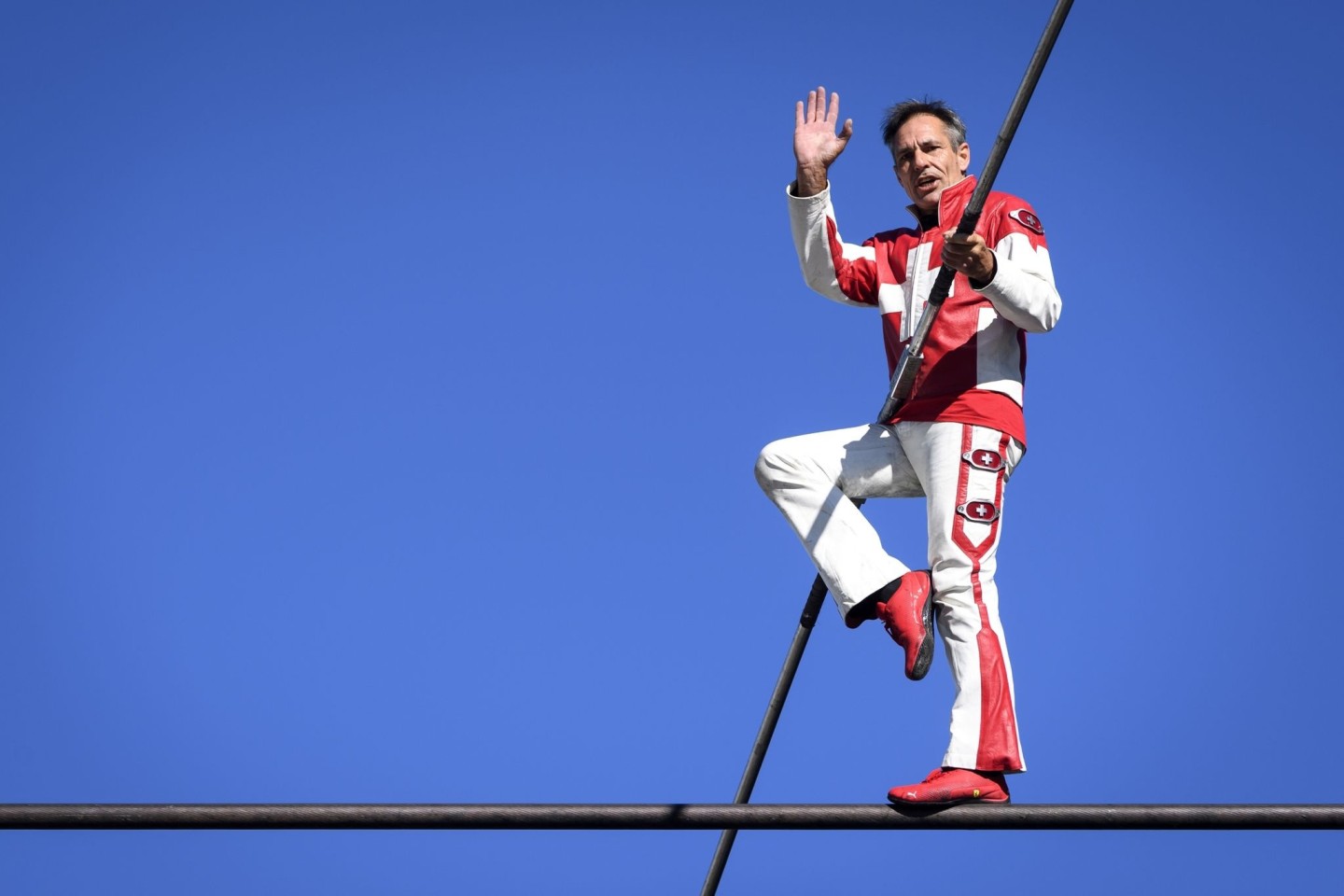 Freddy Nock balanciert auf dem Seil einer Seilbahn.