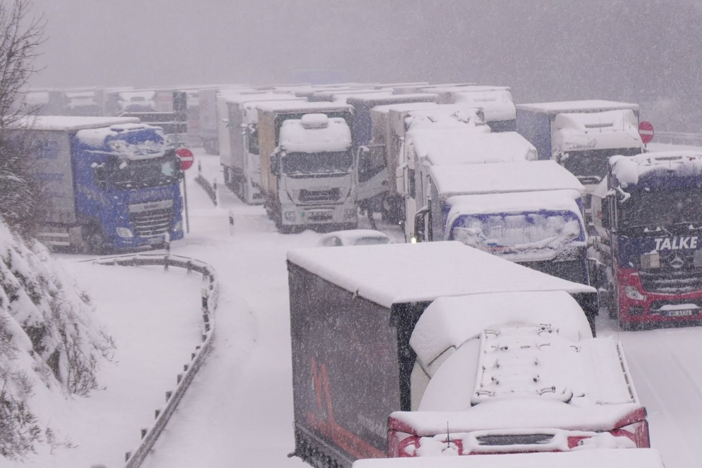 Lastwagen stecken im Stau auf der schneebedeckten Autobahn 5 bei Alsfeld fest.