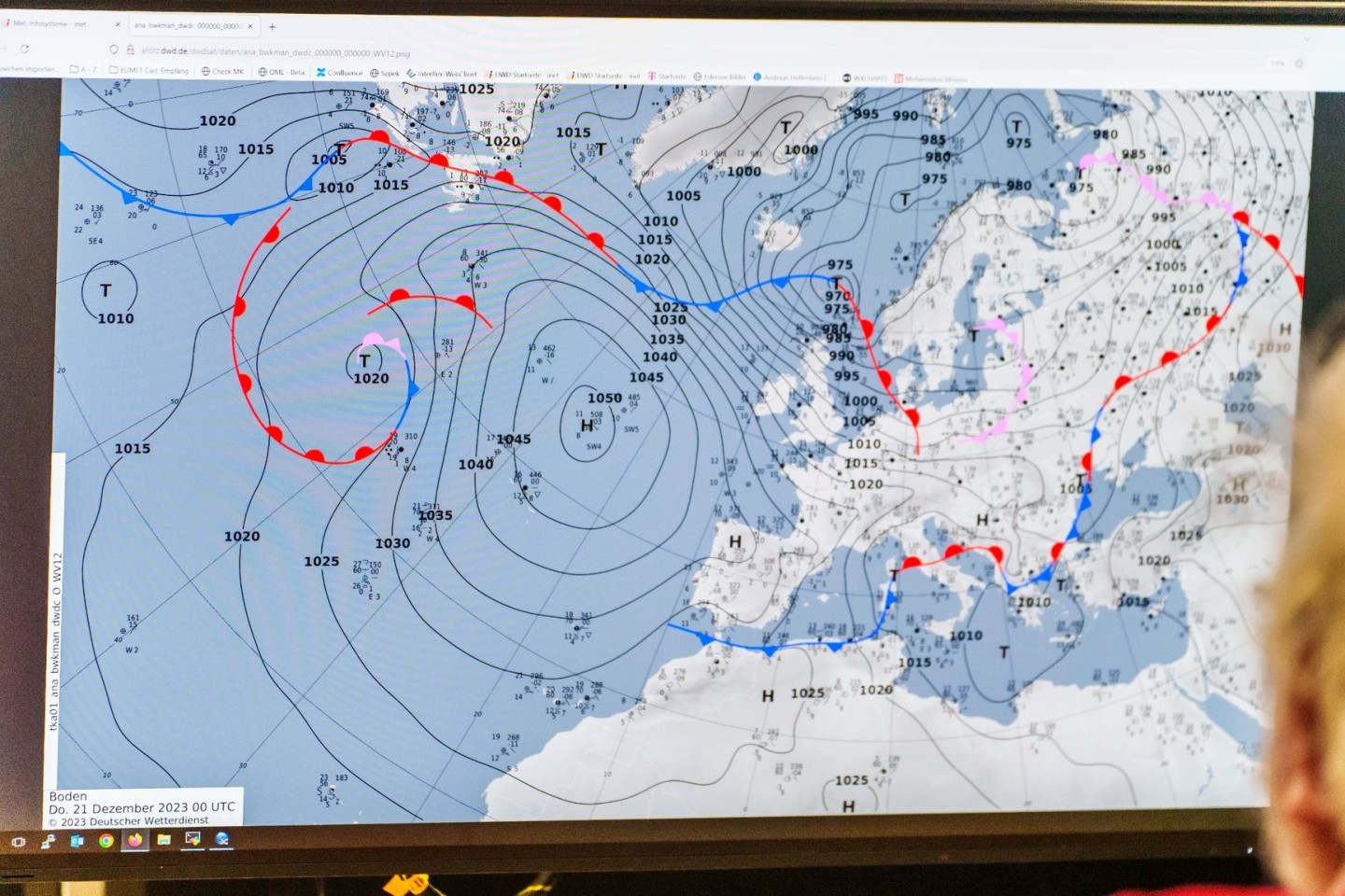 Ein Mitarbeiter des DWD sitzt im Leitstand des Großrechenzentrums vor einem Bildschirm mit einem Vorhersage-Modell.