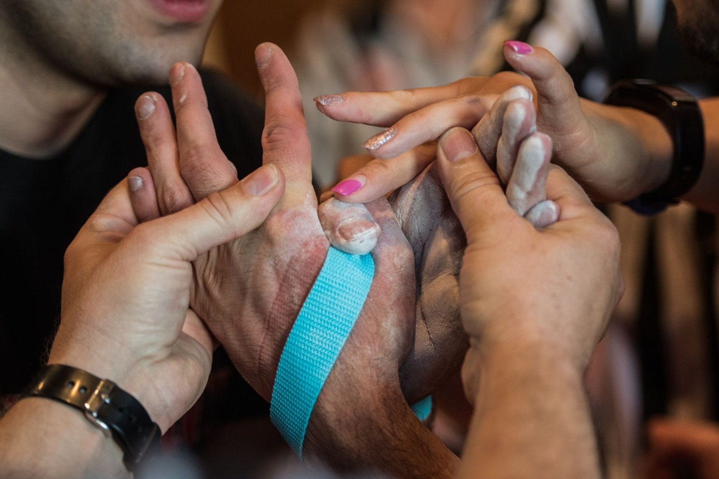 Die beiden Schiedsrichter binden bei den Deutschen Meisterschaften im Armwrestling die Hände der Athleten mit einem Gurt zusammen, um ein erneutes Abrutschen zu verhindern.