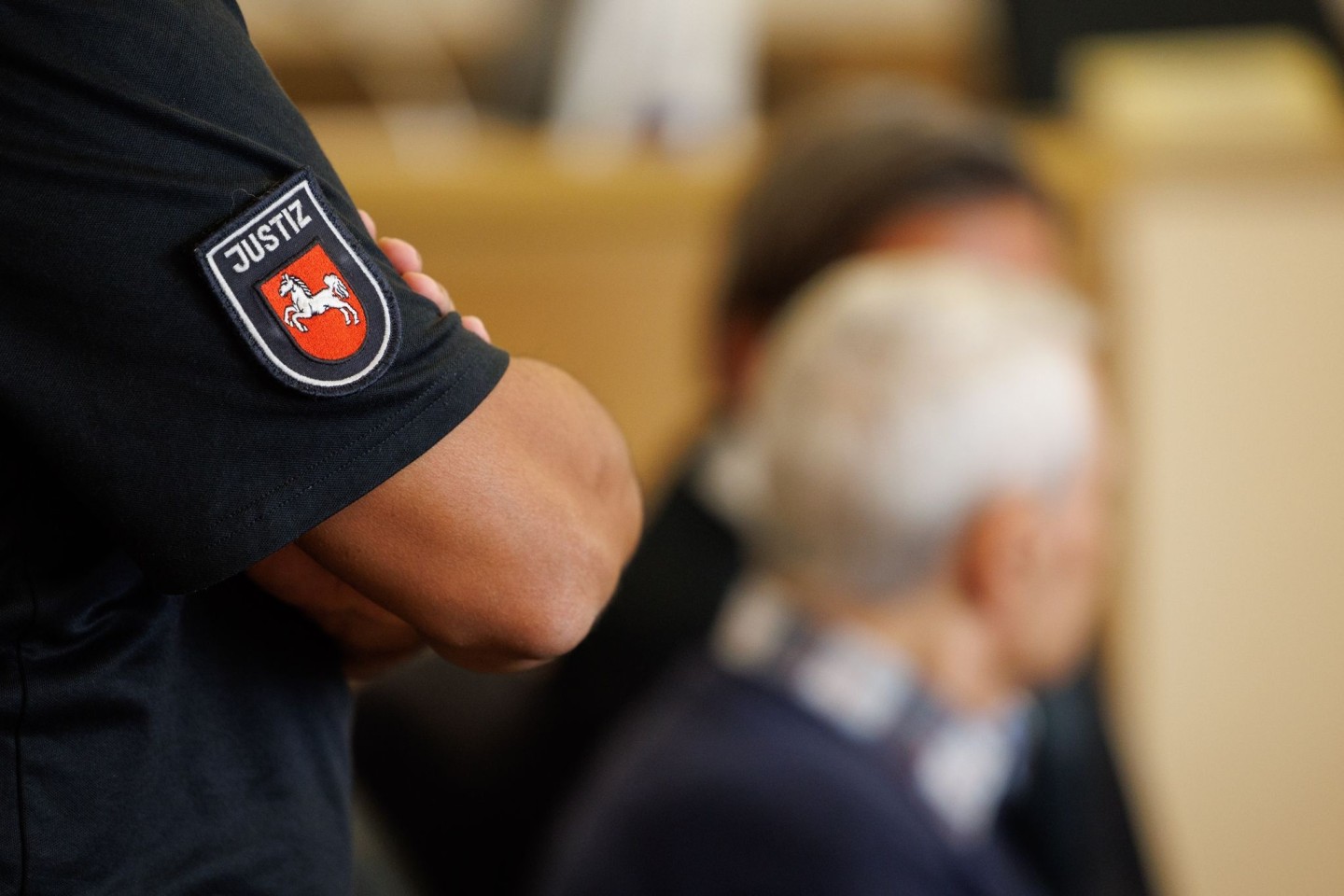 Ein Justizbeamter steht hinter dem Angeklagten im Saal des Landgerichts Osnabrück.