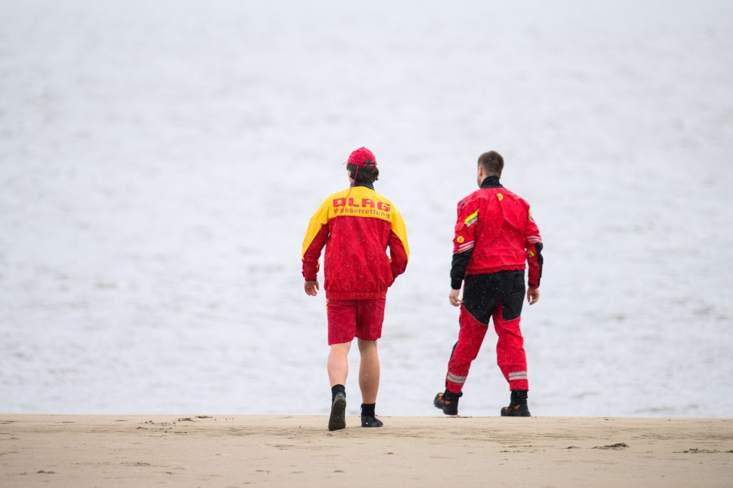 Zwei Mitarbeiter der DLRG an der Elbe.