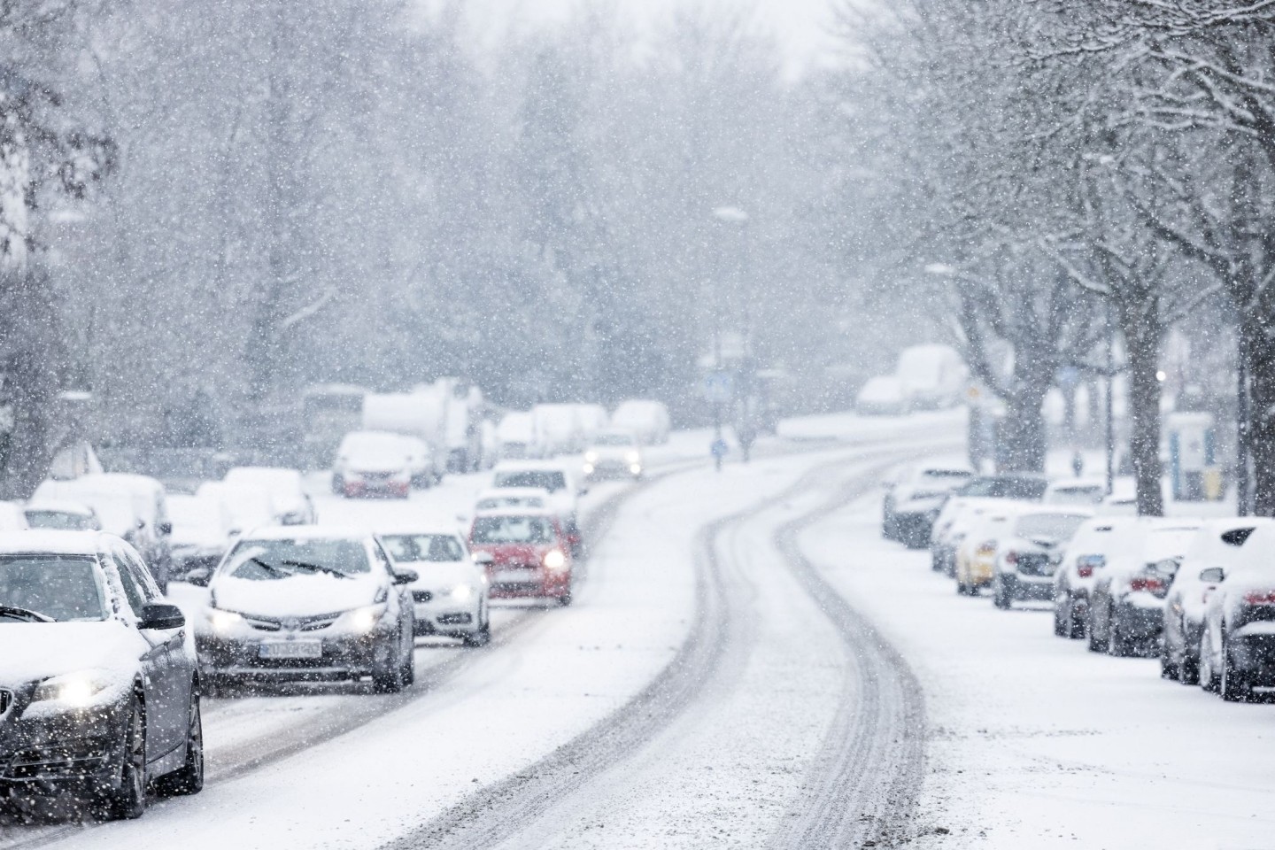 Nur langsam kommen Autos in der Kölner Innenstadt im dichten Schneetreiben voran.