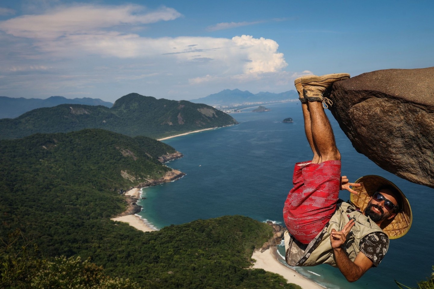 Ein Mann hängt für ein Bild an dem Felsen «Pedra do Telegrafo» bei Rio de Janeiro.